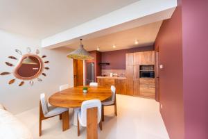 a kitchen and dining room with a wooden table and chairs at Gate 11 Mezzanine one in Denpasar