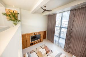 a living room with white furniture and a tv at Gate 11 Mezzanine one in Denpasar