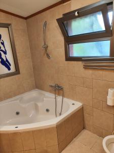 une baignoire dans une salle de bain avec une fenêtre dans l'établissement galilpitality, à Sede Eli‘ezer