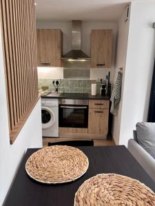 eine Küche mit Tisch und Herd Oberer Backofen in der Unterkunft Le Cocon Vert in Cognac