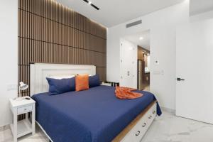 ein Schlafzimmer mit einem großen Bett mit blauer Bettwäsche und orangefarbenen Kissen in der Unterkunft Encantame Soleil studio lock off sleeps 4 in Playa Encanto