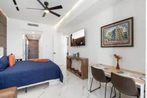 ein Schlafzimmer mit einem Bett und einem Schreibtisch und Stühlen in der Unterkunft Encantame Soleil studio lock off sleeps 4 in Playa Encanto + 47 Fotos