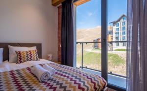 古多里New Gudauri Apartments in Twins的一间卧室，里面有一张床和一扇大窗户。