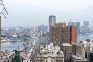 ein Blick auf eine Stadt mit einem Fluss und Gebäuden in der Unterkunft 18th floor Nile View with Jacuzzi in Zamalek in Kairo
