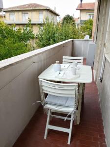 einen kleinen weißen Tisch und Stühle auf dem Balkon in der Unterkunft Il sorriso romagnolo in Misano Adriatico