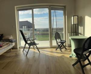 a living room with chairs and a table and a large window at Panorama Biegusa 74 in Gliwice +19 photos