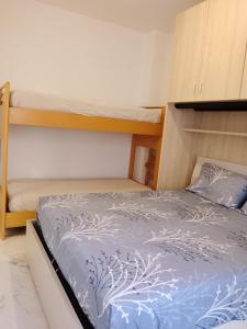 een slaapkamer met twee stapelbedden en een blauw dekbed bij Il sorriso romagnolo in Misano Adriatico