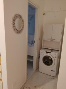 eine Waschküche mit einer Waschmaschine und einem Spiegel in der Unterkunft Il sorriso romagnolo in Misano Adriatico + 9 Fotos