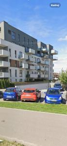 three cars parked in a parking lot in front of a building at Panorama Biegusa 74 in Gliwice