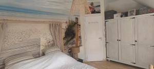 a bedroom with a bed with a painting of a beach at Maison moderne 150 m2 à 15mn du centre ville in Aigné