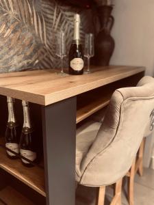 a table with two bottles of wine and a chair at Rooms & Apartment ZALA Near Airport & Cable car in Cerklje na Gorenjskem