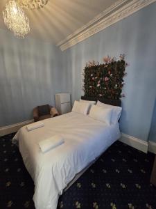 a bedroom with a large white bed with a floral wall at Maqs Bistro in Egremont