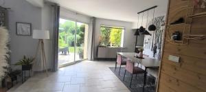 a kitchen with a table and chairs and a large window at Maison moderne 150 m2 à 15mn du centre ville in Aigné