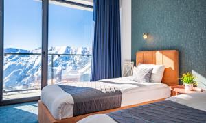 a hotel room with two beds and a large window at New Gudauri Apartments in Twins in Gudauri