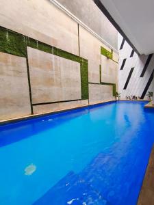 ein Swimmingpool mit blauem Wasser in einem Gebäude in der Unterkunft Villa Gamelas Kusuma Pinus Batu in Batu
