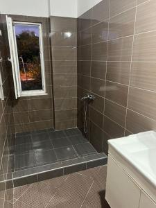 Un baño con ducha con ventana. en Rooftop Gallery Hostel, en Tirana