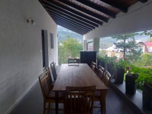 a dining room table with chairs and a large window at Cazare Casa Vio BORSA in Băile Borşa