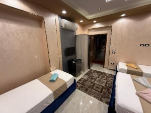 Habitación pequeña con 2 camas y TV. en Cairǒ-Plazǎ UP Hotel, en El Cairo