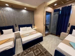 Una habitación de hotel con dos camas y un baño. en Cairǒ-Plazǎ UP Hotel, en El Cairo