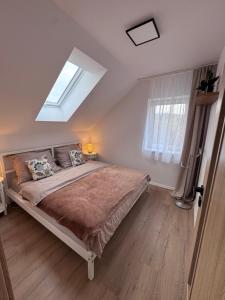 a bedroom with a large bed and a skylight at Apartmán Veronika in Humpolec