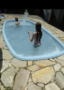 two children are playing in a swimming pool at Casarão Petrópolis Vintage - Hostel & Suítes in Petrópolis