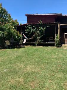 ein Haus mit einem Garten mit Stühlen und einem Haus in der Unterkunft Casa en La Barra para 5 in Punta del Este