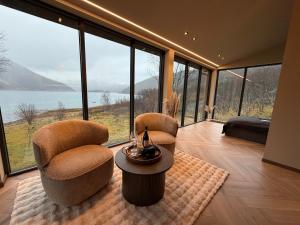 two chairs and a table in a room with large windows at Aurora Suite in Tromsø +20 photos