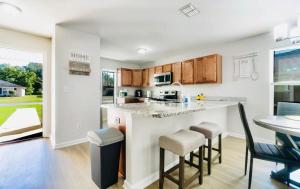 a kitchen with a counter and stools in a room at Cozy 4 BR Abode in Jacksonville