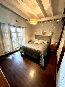 ein Schlafzimmer mit einem großen Bett und einem großen Fenster in der Unterkunft Casa en La Barra para 5 in Punta del Este