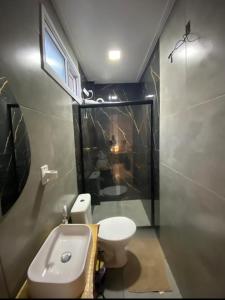 une petite salle de bain avec toilettes et douche dans l'établissement Vida & Brisa, à Pelotas