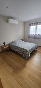 a bedroom with a bed and a wooden floor at Villa 4 chambres, jardin, Netflix in Canohès