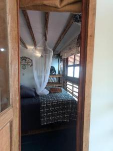 a bed in a small room with a curtain at cozy studio in Máncora