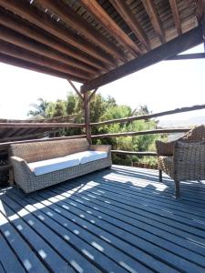 eine Terrasse mit zwei Stühlen und einer Couch darauf in der Unterkunft cozy studio in Máncora + 10 Fotos