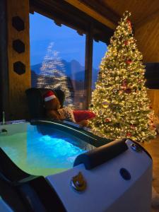 a christmas tree with a teddy bear sitting in a chair next to at View Apartament Kasprowy Wierch Premium DeLuxe & SPA in Kościelisko