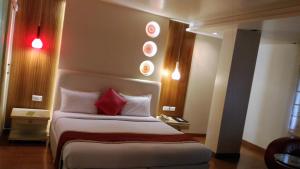 Cette chambre comprend un lit avec des oreillers rouges. dans l'établissement Taj Tristar, à Hyderabad