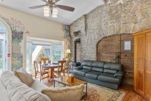 a living room with a couch and a stone wall at Noble Suites in Brockville