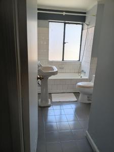 ein Badezimmer mit Waschbecken und Toilette und einem Fenster in der Unterkunft Casa Quinta Vergara in Viña del Mar