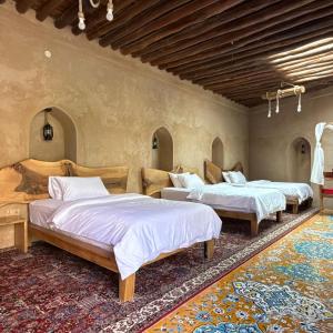 a bedroom with three beds in a room at Beit Al Fateh بيت الفتح in Fatḩ Āl Bū Sa‘īd