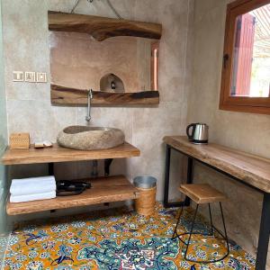 a bathroom with a sink and a table and a stool at Beit Al Fateh بيت الفتح in Fatḩ Āl Bū Sa‘īd