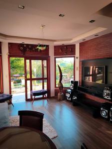 a living room with a fireplace and a television at Pousada Finca dos Anjos in Passa Quatro