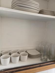 ein Regal mit Tellern, Schalen und Geschirr darauf in der Unterkunft Casa Quinta Vergara in Viña del Mar + 13 Fotos