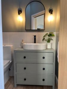 a bathroom with a white sink and a mirror at The Summer House - Tiny Home with Hot Tub in Coity