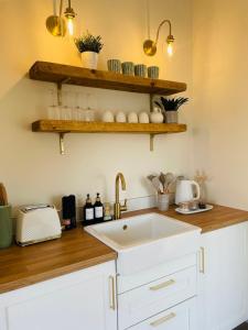a kitchen with a sink and wooden counter top at The Summer House - Tiny Home with Hot Tub in Coity +8 photos