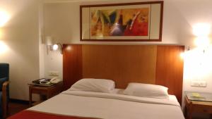 a bedroom with a bed and a picture on the wall at Taj Tristar in Hyderabad +74 photos
