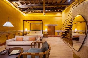 a bedroom with a bed and a couch in a room at Casa Carolina Luxury Wellness Hotel in Cartagena de Indias
