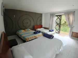 a bedroom with two beds and a window at Villa campestre en conjunto residencial in Arbeláez