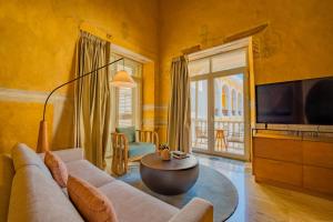 a living room with a couch and a tv at Casa Carolina Luxury Wellness Hotel in Cartagena de Indias +66 photos