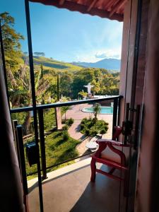 a room with a view of a pool and a chair at Pousada Finca dos Anjos in Passa Quatro +19 photos