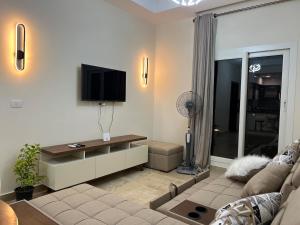 阿莱曼Ilatini New Alamein Lagoon View - الحي اللاتيني的配有沙发和平板电视的客厅