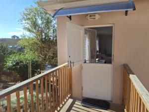 eine Veranda eines Hauses mit blauer Markise in der Unterkunft Large room in quiet north facing suburb in Knysna + 19 Fotos